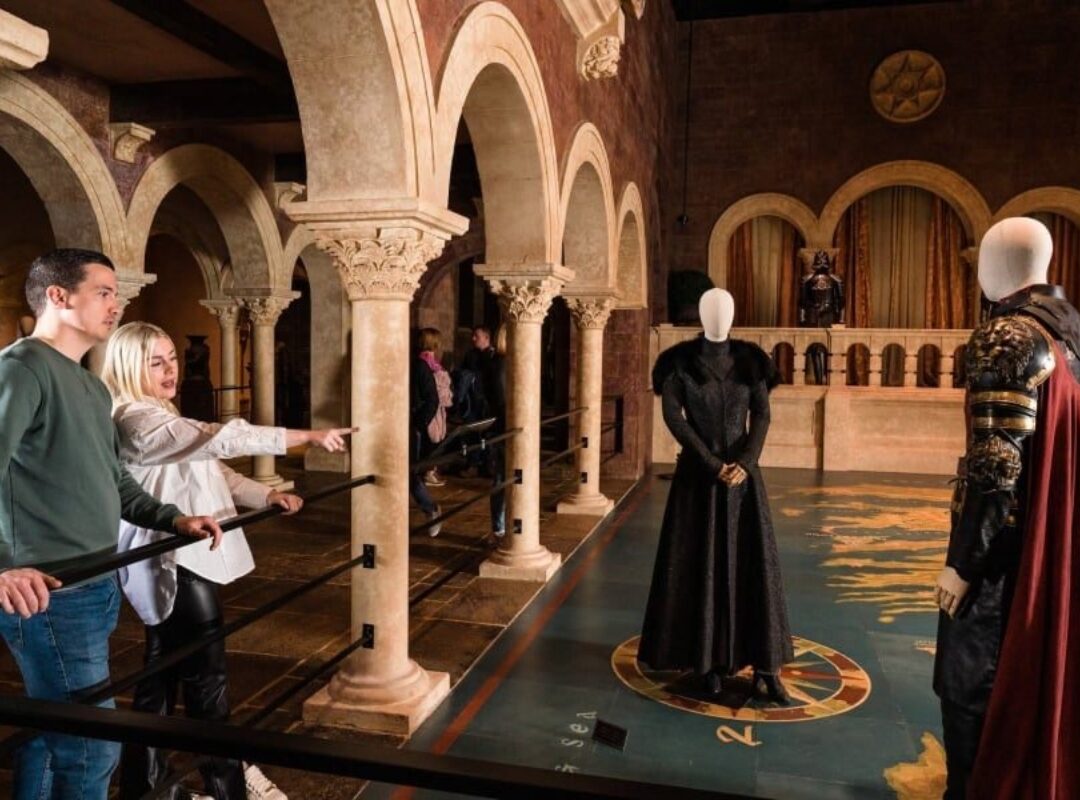 Couple looking at kings landing map with costumes